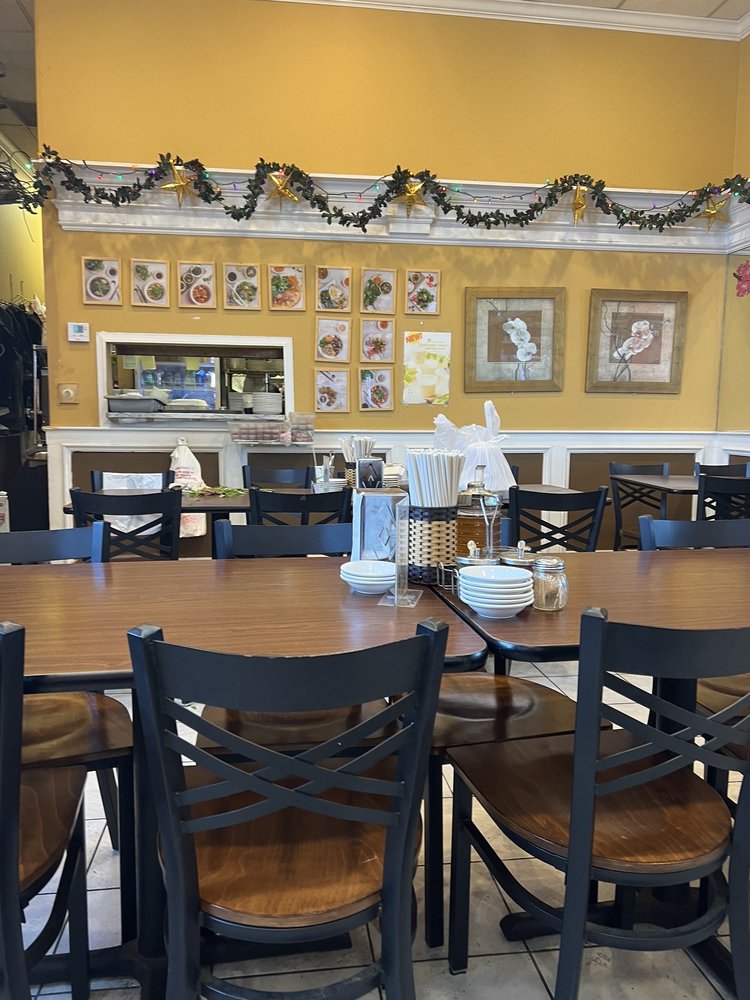 The warm dining room of Banh Cuon Saigon with lanterns and menu photos on the wall